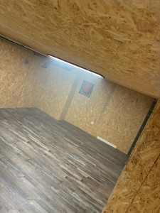 Photo de galerie - Après travaux : cave assainie et aménagée en salle de sport. Cuvelage murs et sol, ventilation, ossature et OSB, électricité et sol PVC.