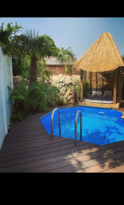 Photo de galerie - Pose d’une piscine en bois avec terrasse composite et création de faux rocher avec aménagement paysagé
