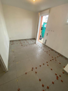 Photo de galerie - Pose de carrelage grand format avec système de nivellement pour garantir une surface parfaitement plane, des joints réguliers et une finition de haute qualité.