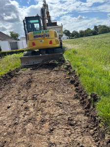 Photo de galerie - Travaux de terrassement et de préparation de terrain avec mini-pelle. Décapage, nivellement et mise en forme du sol pour un futur chantier.