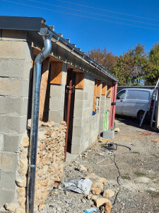 Photo de galerie - Pose de gouttières demi-rondes en zinc, développement 25, avec fourniture et pose des tuyaux de descente, coudes et fixations nécessaires. Réalisation des soudures à l’étain pour assurer une étanchéité durable.