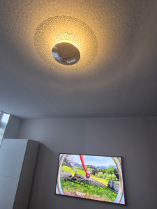 Photo de galerie - Installation d'un luminaire accroché au plafond et fixation d'un téléviseur mural.