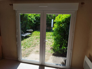 Photo de galerie - Pose d'une porte fenêtre deux vantaux en PVC avec reprise du seuil pour l'étanchéité. 