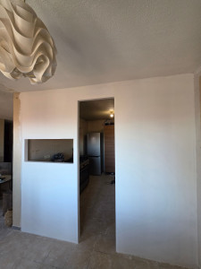 Photo de galerie - Création d'une cloison séparative en plaques de plâtre avec ouverture pour porte et passe-plat. Finitions et bandes à joint réalisées.