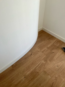 Photo de galerie - Découpe et ajustement des plinthes sur mesure pour suivre la forme arrondie du mur 