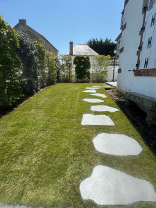 Photo de galerie - Aménagement général du jardin : pose de gazon de placage, plantation de végétaux palissés, mise en place de pas japonais et arrosage automatique 