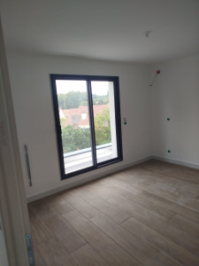 Photo de galerie - Peinture intérieure d'une pièce. Murs blancs et pose de parquet. Finition propre et lumineuse.