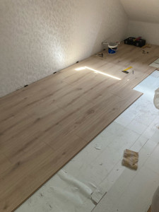 Photo de galerie - Pose parquet stratifiée dans une chambre.