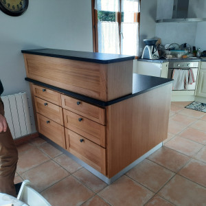 Photo de galerie - Fabrication d'un buffet de cuisine. Cadre en massif rapporté sur le caisson avec des tiroirs en queue d'aronde et façade assemblée. Le tout vernis. De l'autre côté ,le tout laqué est en blanc afin de s'accorder avec la cuisine.  Plan de travail en pierre.