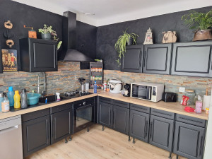 Photo de galerie - Finition laque noire mate et pose d'une cuisine avec plan de travail chêne. 