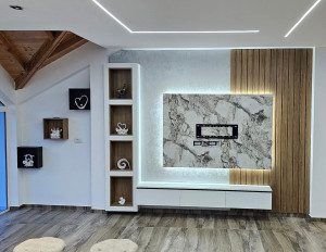 Photo de galerie -  aménagement mural sur mesure pour meuble TV avec panneau effet marbre latte en bois et éclairage LED intégré.