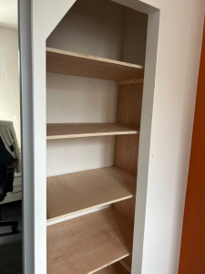 Photo de galerie - Conception et fabrication d'un ensemble d'étagères sous un escalier.