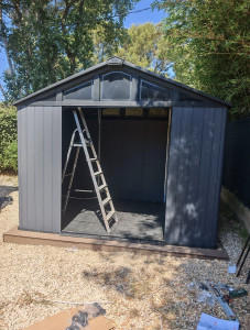Photo de galerie - Montage et pose d’un abri de jardin préfabriqué directement sur la terrasse en bois composite.