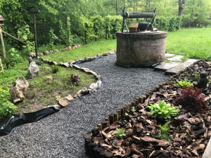 Photo de galerie - Aménagement d’un chemin en cailloux à la main au milieu d’un parterre de fleurs (photo non finale)