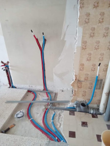 Photo de galerie - Installation de la distribution d’eau et des évacuations avant la pose d’un bac à douche et d’un toilette encastrable.